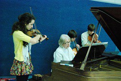 Marlyn Mainard and her students play a prelude as people gather